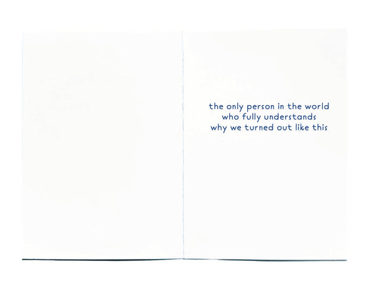 An open white greeting card with blue text on the right panel reading, 'the only person in the world who fully understands why we turned out like this.'.