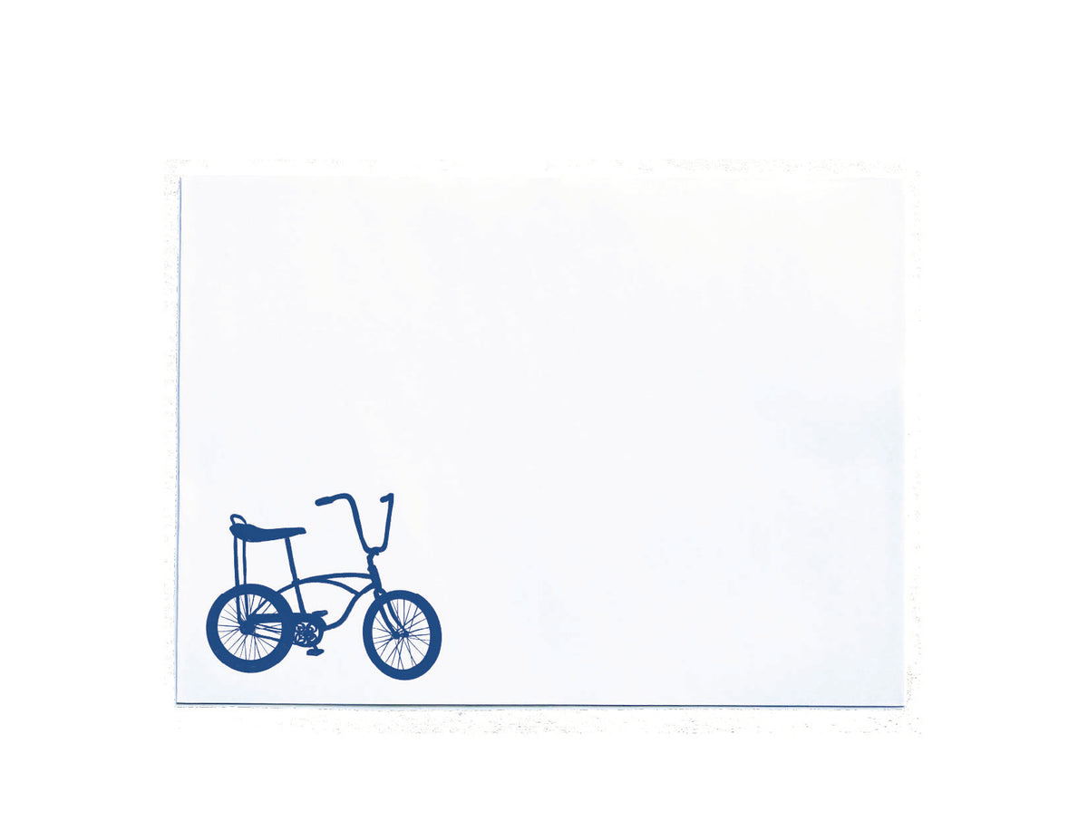 A white rectangular card or envelope featuring a simple blue line drawing of a bicycle in the lower-left corner, shown on a white background.