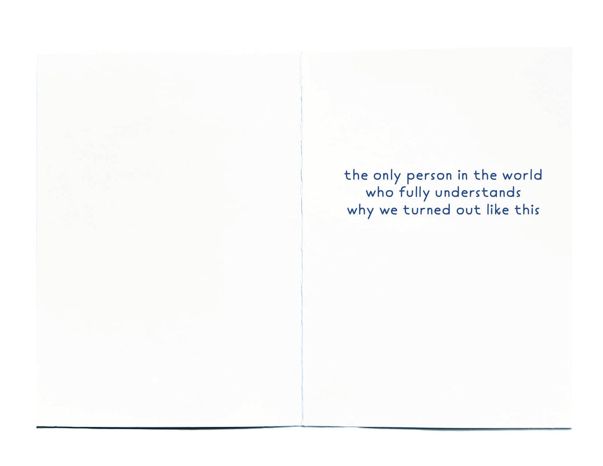 An open white greeting card with blue text on the right panel reading, 'the only person in the world who fully understands why we turned out like this.'.