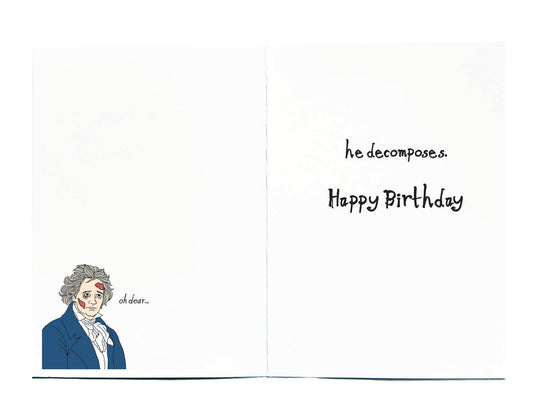 A folded greeting card shown open, with a white front and back. The left panel features a small illustrated portrait of a person in a blue coat at the lower left, on right side of card it reads he decomposes. Happy Birthday.