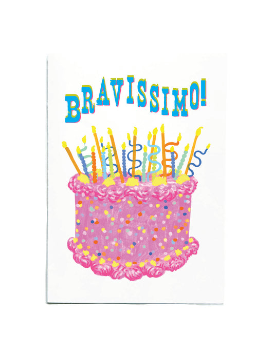 A white greeting card featuring a colorful illustration of a birthday cake with candles and the word 'BRAVISSIMO!' in playful blue letters at the top.