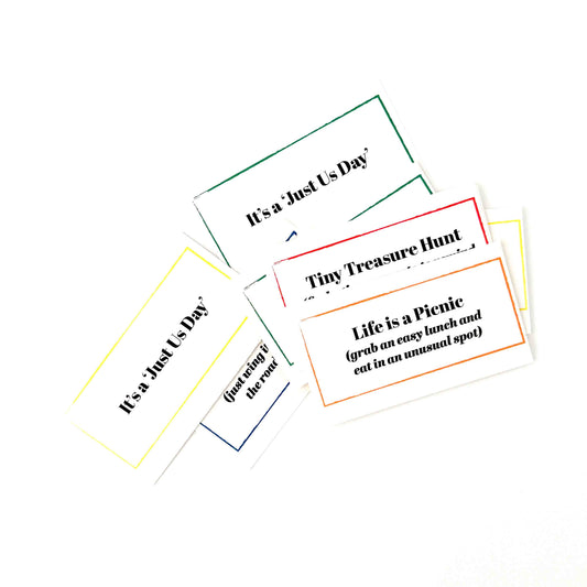 Five small rectangular printed cards with colorful borders and black text, arranged on a plain white background. The visible phrases include 'It's a-Just Us Day', 'Tiny Treasure Hunt', and 'Life is a Picnic'.