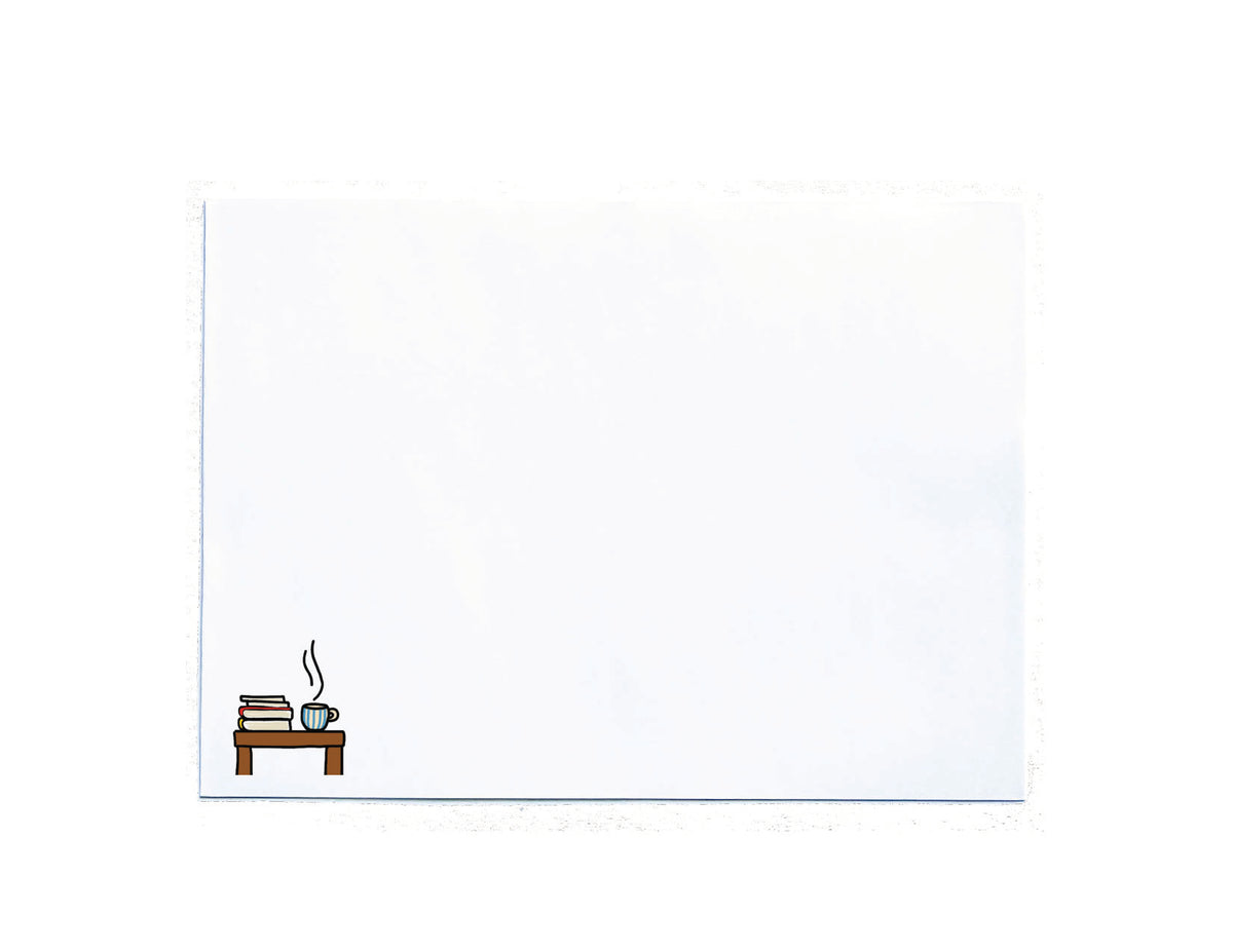 A white envelope with a small illustrated scene in the bottom-left corner showing a small brown table, stacked books, and a blue cup with steam