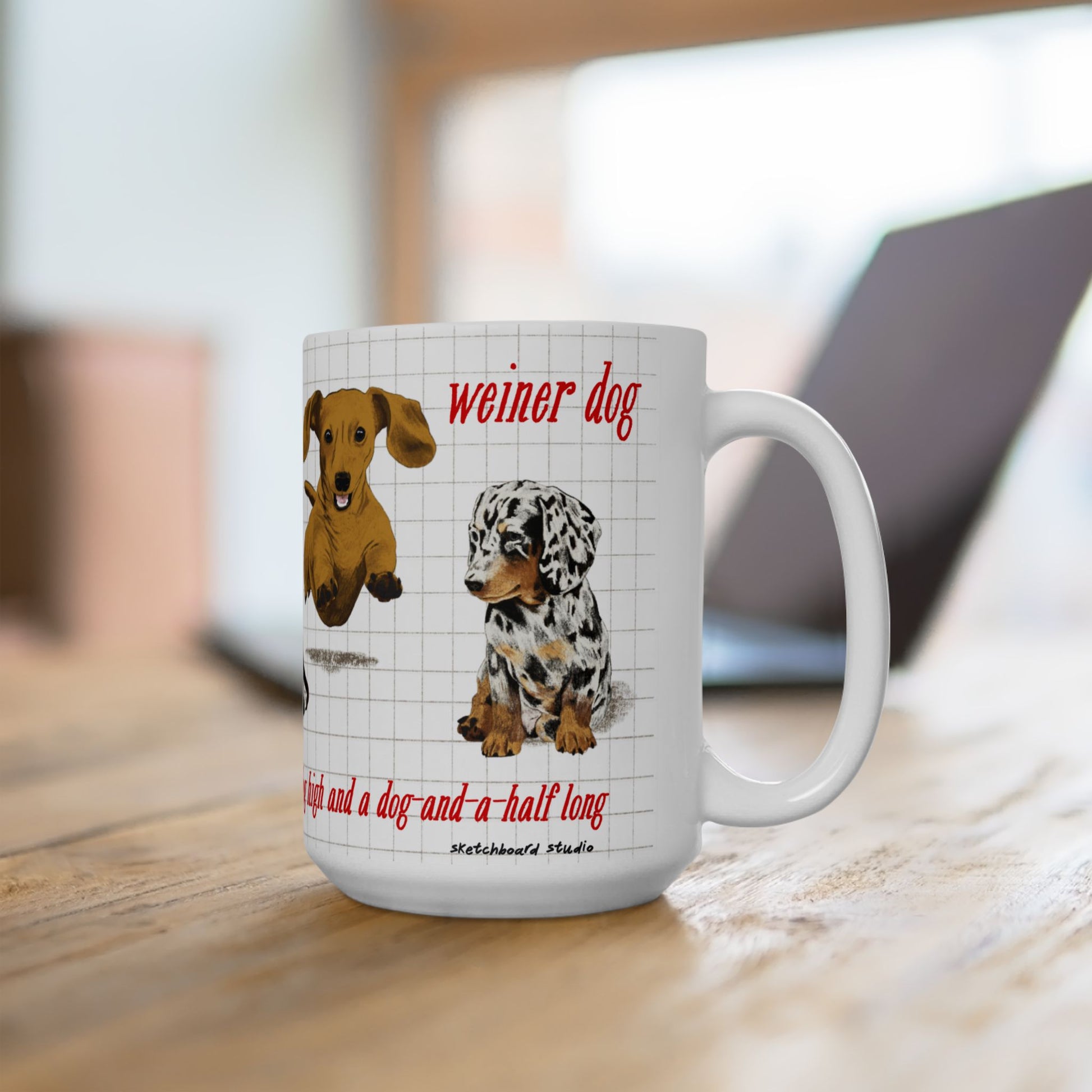White mug with dachshund dog illustrations and text on a wooden surface